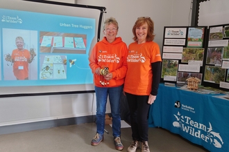 Two people delivering a presentation at a Team Wilder empowerment day.