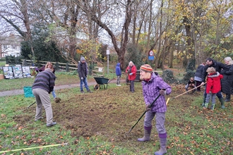 people preparing the ground for grass and flower seed sowing.