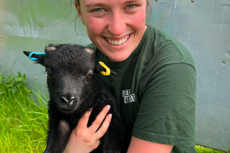 Trainee Savannah holding a Hebridean lamb