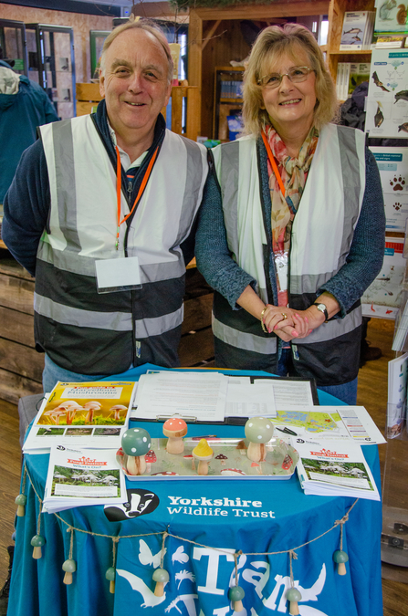 2 YWT volunteers greeting visitors at a welcome desk, Potteric Carr