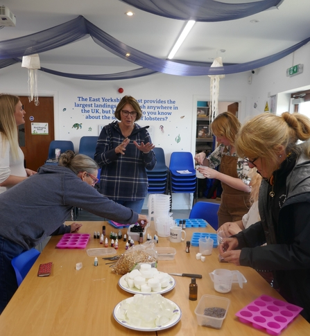 Volunteers around a table making soap